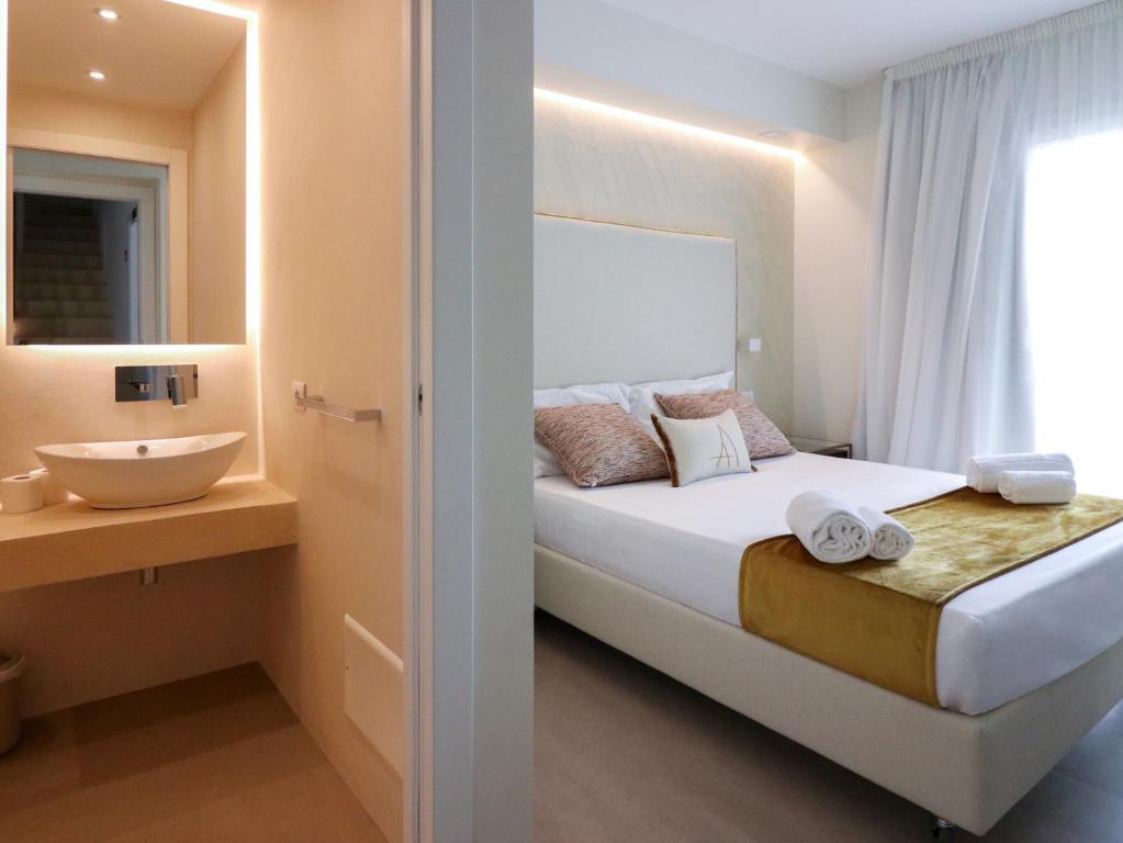 a small bedroom with a bed and a sink at Double A Luxury Room in Olbia
