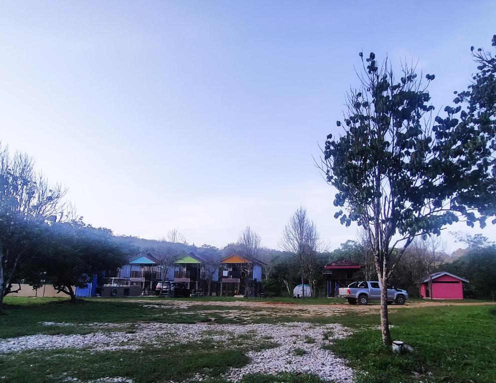 a car parked in front of a group of houses at Dusun Rimbun Agro Farmstay in Kuala Kerai