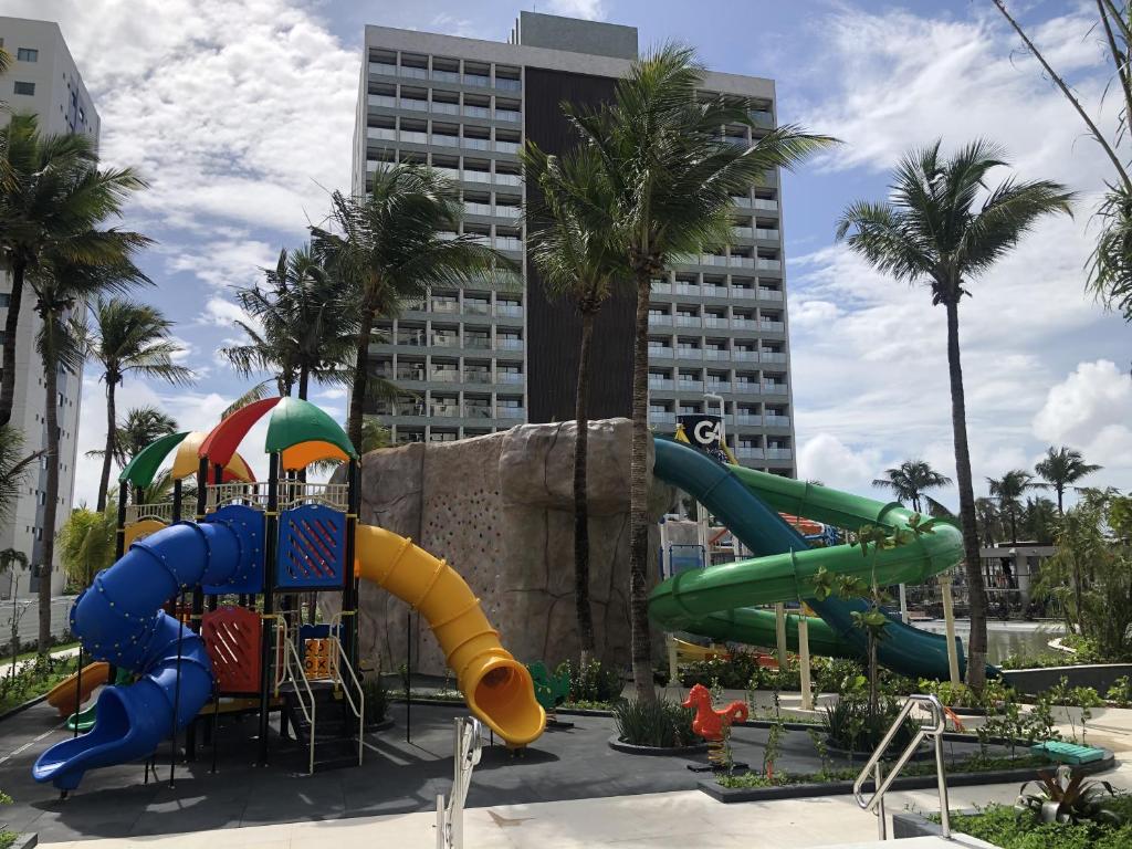 un parc aquatique avec un toboggan en face d'un bâtiment dans l'établissement Salinas Premium Resort - Quarto Linda Vista, à Salinópolis