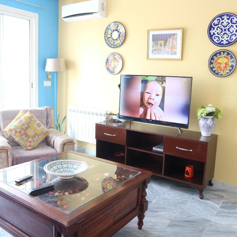 a living room with a tv and a coffee table at The Pearl Apartment Hammam Sousse WIFI in Sousse