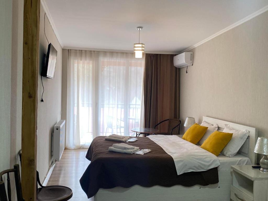 1 dormitorio con 1 cama grande con almohadas amarillas en Jorjadze street 23, en Borjomi
