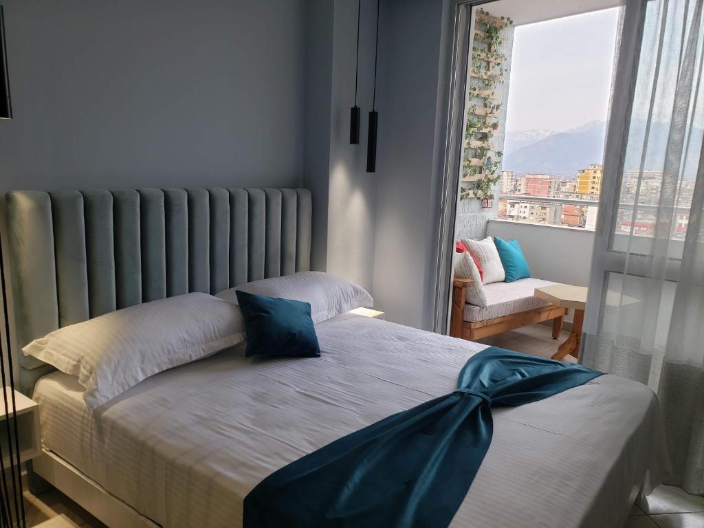 um quarto com uma cama e uma grande janela em Appartamento Nr. 28. Centrale e luminoso em Shkodër
