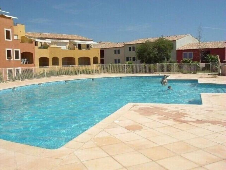 une grande piscine avec une personne dans l'eau dans l'établissement Bel appartement pour 6 personnes dans résidence avec piscine 500 m plage, à Cavalaire-sur-Mer