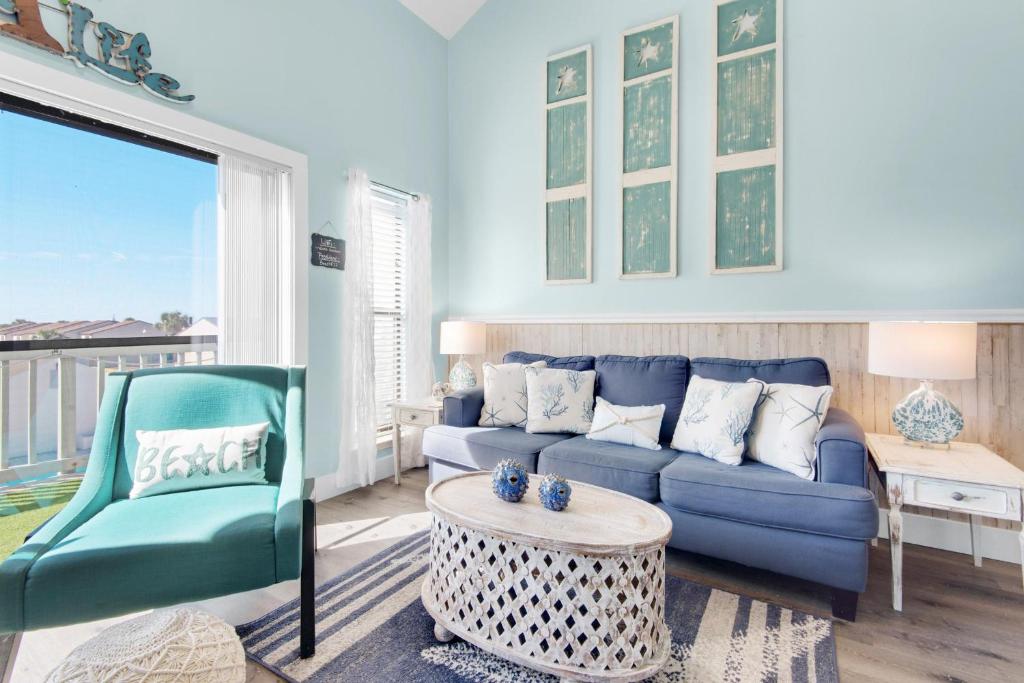 een woonkamer met een blauwe bank en een stoel bij Endless Summer F11 in Panama City Beach
