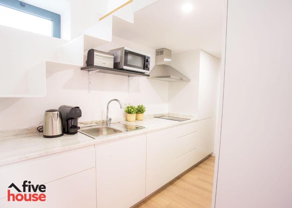 una cucina bianca con un lavello e un forno a microonde di Five House 14A a Porto