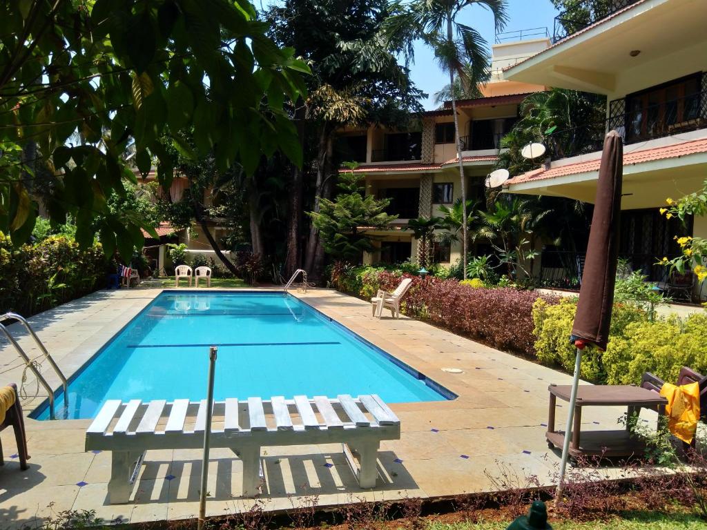 una piscina con sedie a sdraio accanto a un edificio di Haven Amidst Nature in Villa Palmas, Arpora a Goa Velha