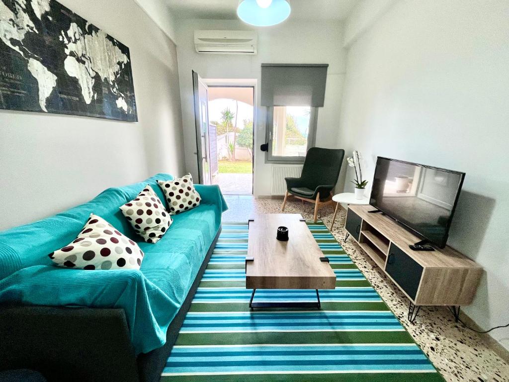 a living room with a blue couch and a tv at Golden Key apartments in Chania Town