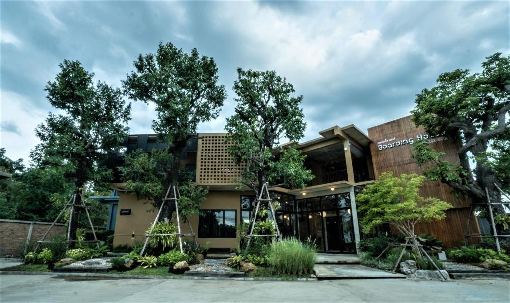 a building with trees in front of it at โรงแรม บอร์ดดิ้งเฮ้าส์ in Ban Bang Yai Chuai