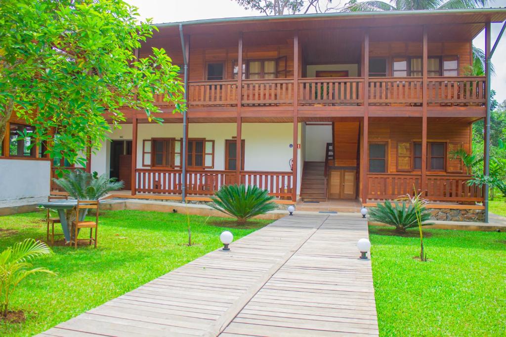 a house with a wooden walkway in front of it at Welfare AgroTurismo in Milagrosa