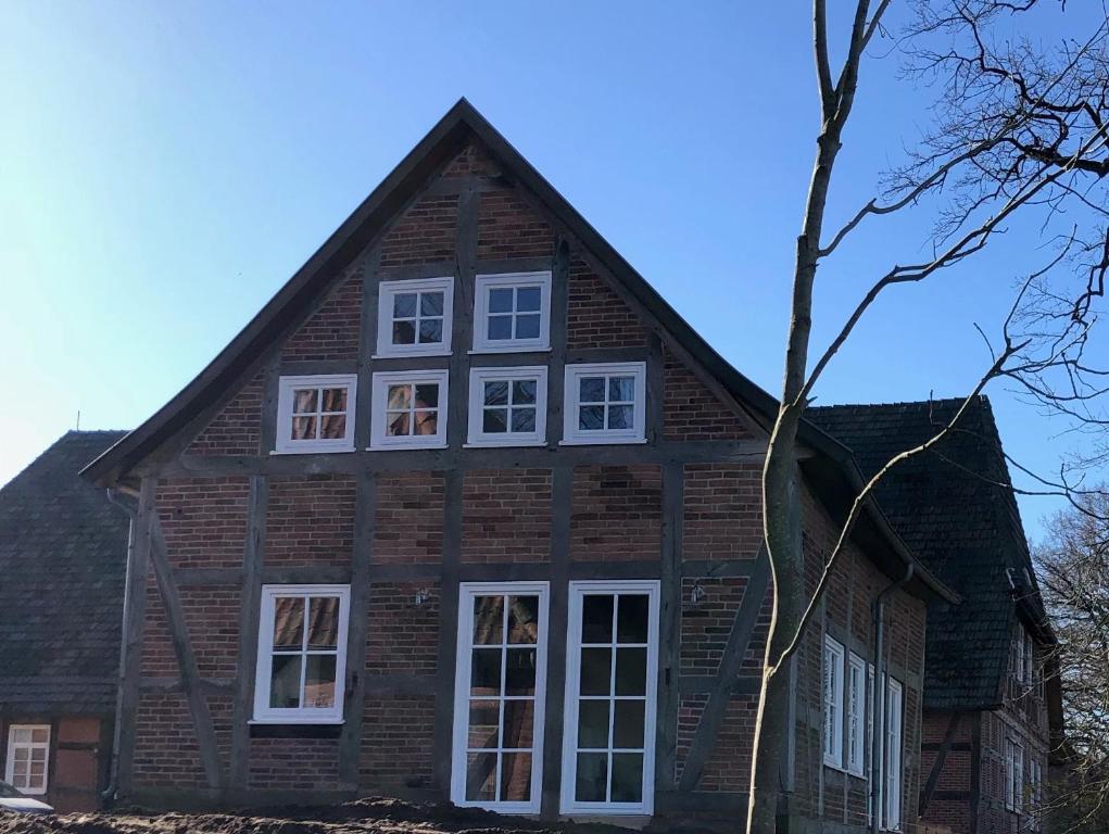 a house with white windows on the side of it at Altes Backhaus Bauernhof Vogel in Rohrsen