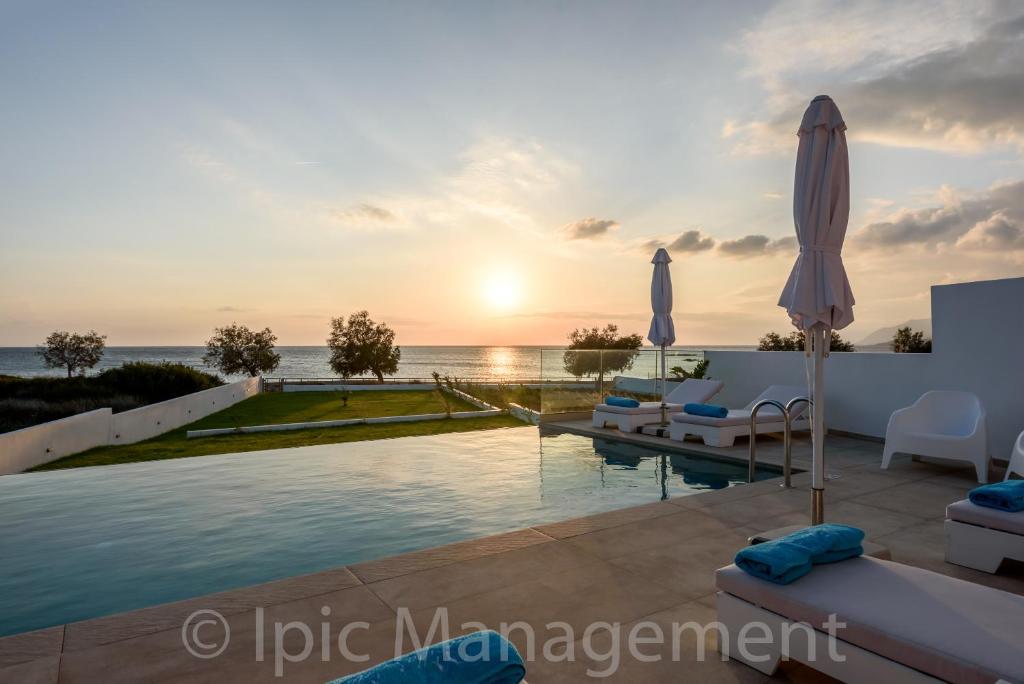 Villa con piscina y océano al atardecer en Seafront VILLA PELAGIA SUPERB New listing2021, en La Canea