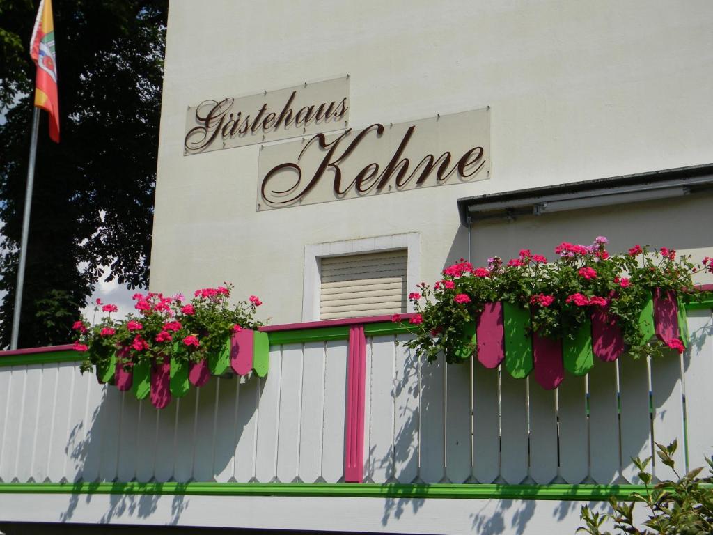 a white building with flowers on a fence at Gästehaus Kehne in Horn-Bad Meinberg