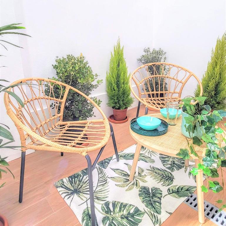 two wicker chairs and a table with potted plants at The Shore @ Surf Paradise - Patio Terrasse in Espinho