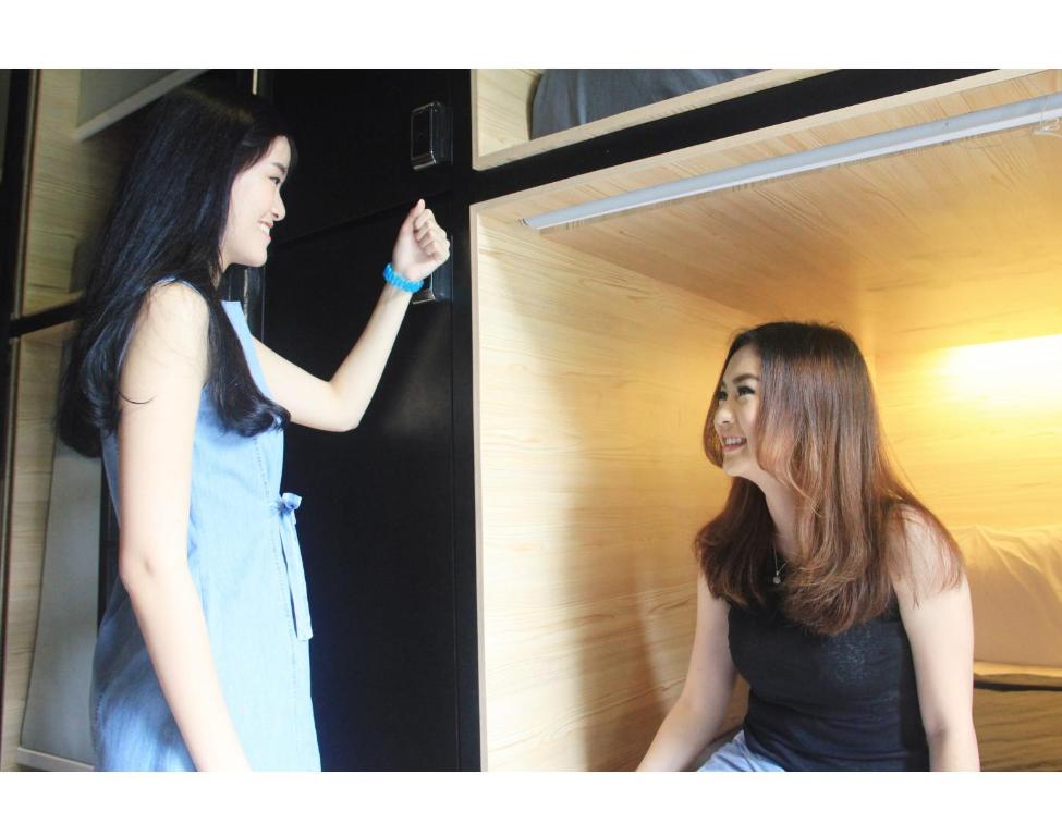 a woman laughing while looking at herself in a mirror at My Studio Hotel Juanda Airport Surabaya in Sedati