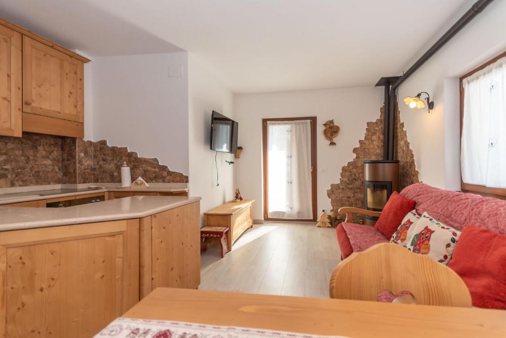 a kitchen and living room with a red couch at Miralago in Alleghe