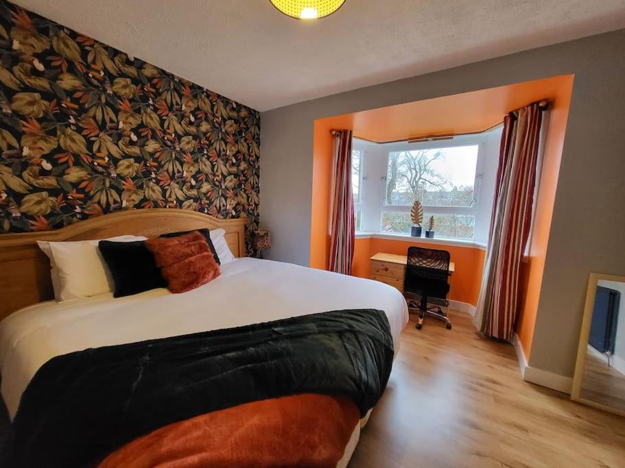 a bedroom with a large bed and a window at 4 Bedroom Apts at Sensational Stay Serviced Accommodation Aberdeen- Powis Crescent in Aberdeen
