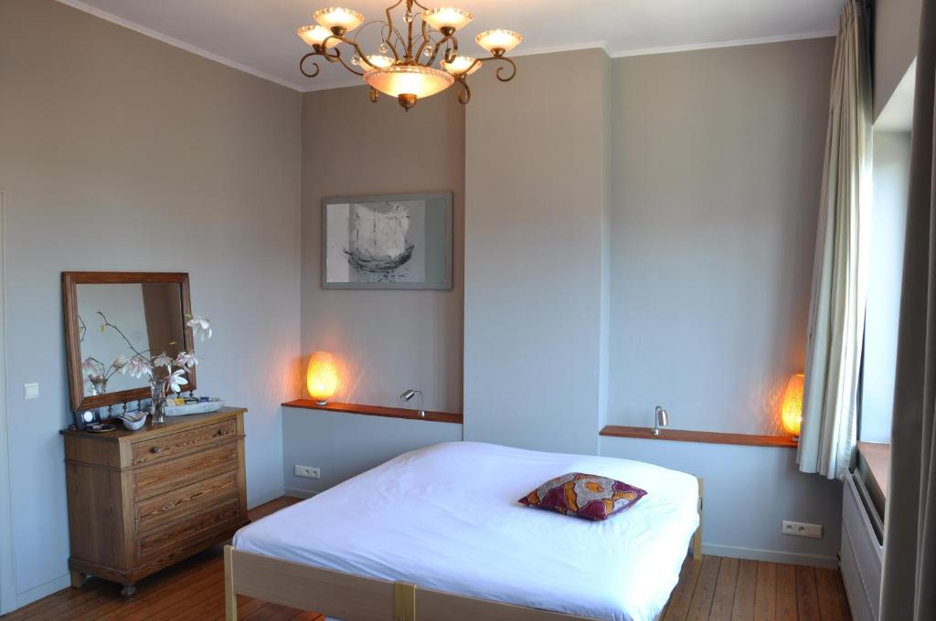 een slaapkamer met een bed, een dressoir en een spiegel bij W'allons nous dormir in Luik