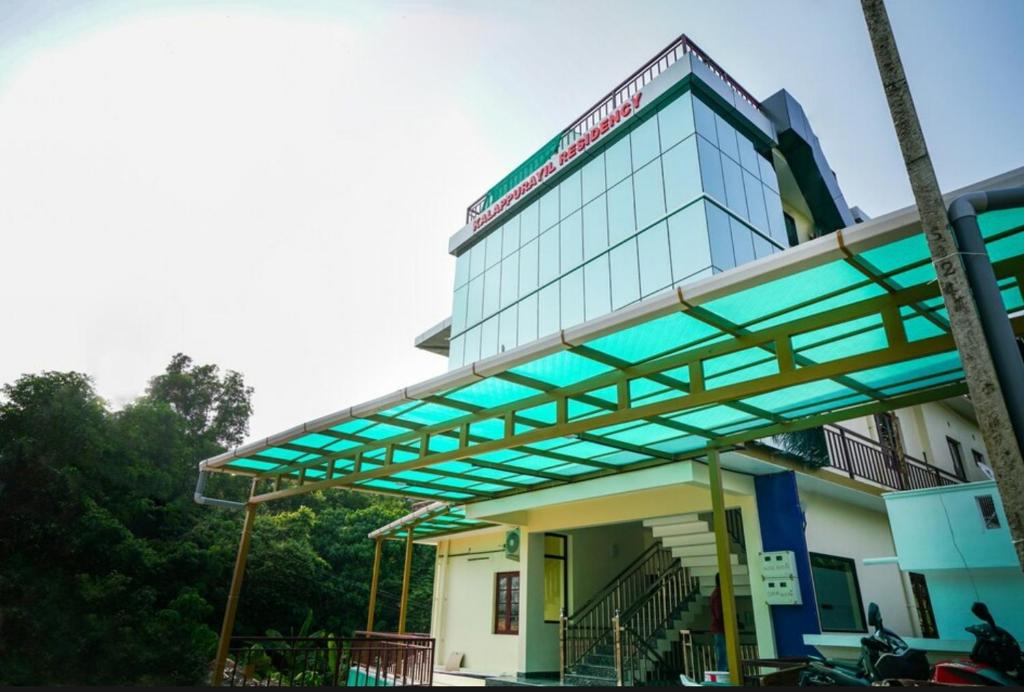 a gas station with a glass building at Kalapurayil Residency in Kakkanad