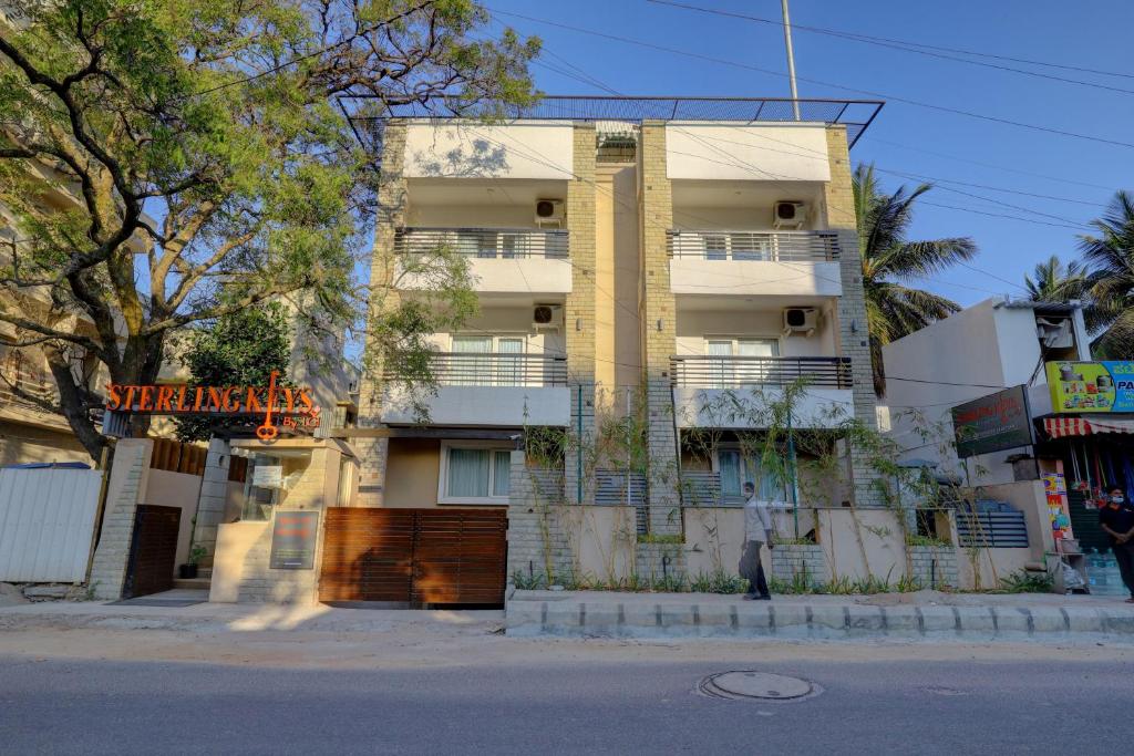 a man is standing in front of a building at Sterling Keys by TGI in Bangalore