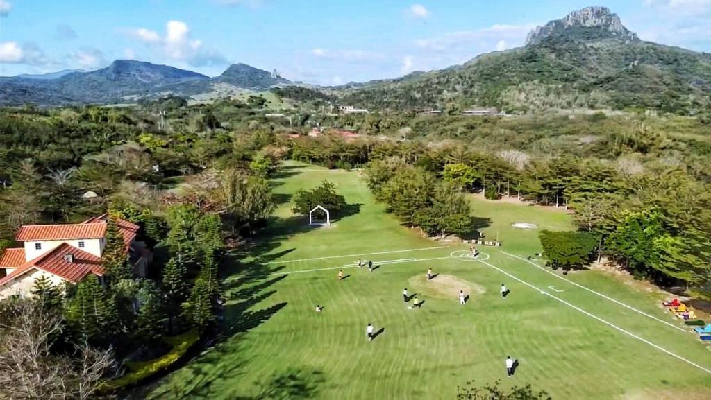 an aerial view of a park with mountains in the background at Kenting Tuscany Resort in Kenting