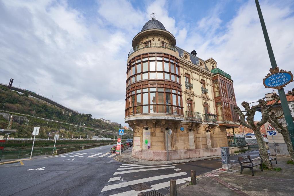 a building with a tower on the side of a street at Apartamento BIO Exclusivo con mirador en Bilbao y aparcamiento público gratuito in Bilbao