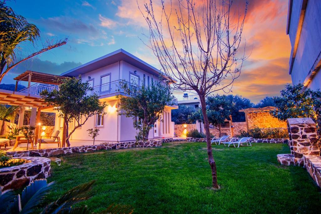 a house with a green yard with a tree at Bitsakis Family - Paleochora Luxury Villa in Palaiochóra