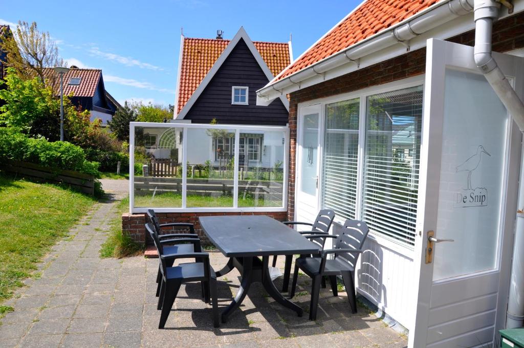 a table and chairs on the back patio of a house at De Snip in Callantsoog