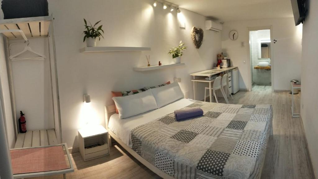 a bedroom with a large bed and a kitchen at Dudi's Peppers in Málaga