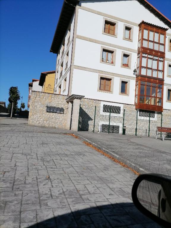 - un grand bâtiment blanc dans une rue pavée dans l'établissement capricho 2 asturias COLOMBRES, à Ribadedeva
