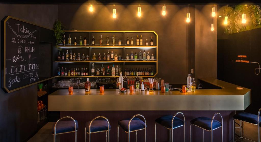 a bar with blue stools and a counter with drinks at Hôtel Tandem - Boutique Hôtel in Strasbourg