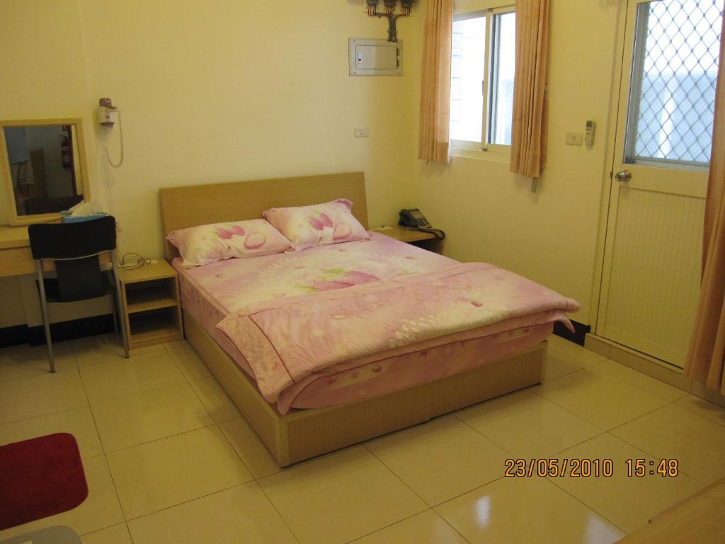 a bedroom with a bed with pink sheets and pillows at The Beauty of Basalt B&amp;B in Magong