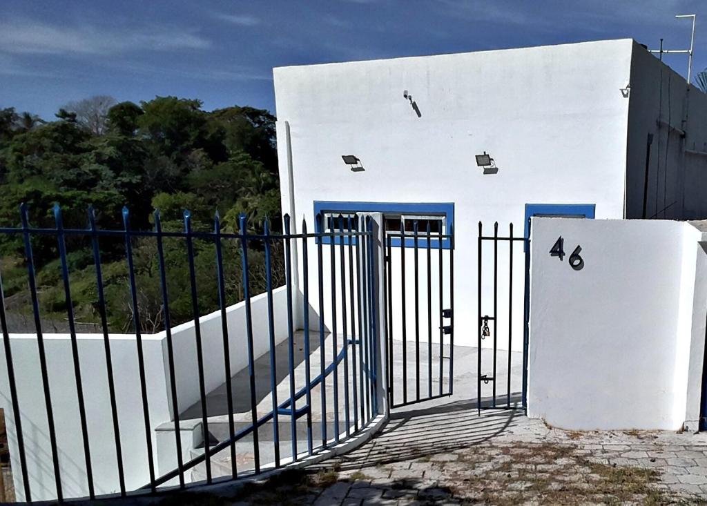 Un edificio blanco con una puerta delante. en La Leona 1, en El Zonte