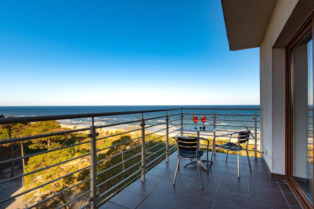 a balcony with a table and chairs and the ocean at Apartament Baltic Sea Gate Porta Mare 55m2 in Dziwnówek