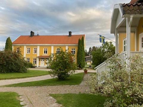 uma grande casa amarela com uma bandeira em frente em Central lägenhet med gratis parkering em Lindesberg