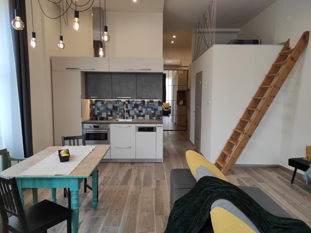 a living room with a table and a kitchen at City Art Inn in Szeged