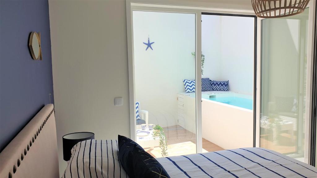 a bedroom with a bed and a bathroom with a tub at The Shore @ Atlantic Beach - Waterfront Beach House, Tiny Pool, Terrasse in Espinho