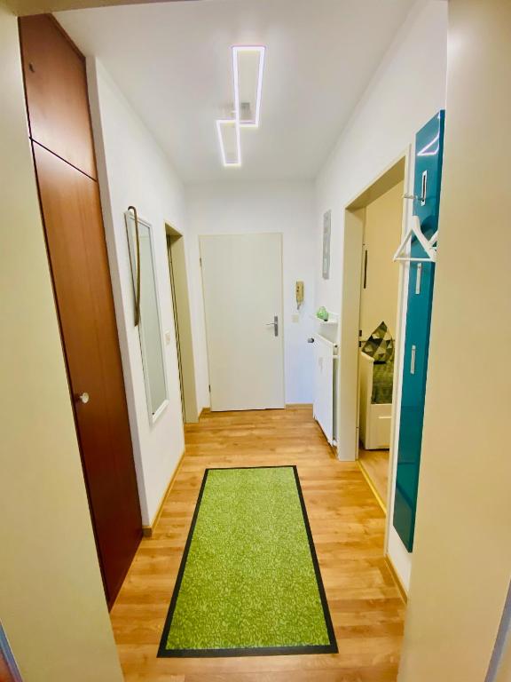 a hallway with a green rug in a room at Strandnixe Cuxhaven in Cuxhaven