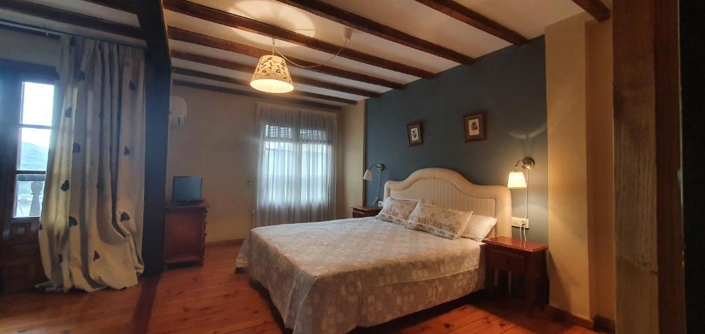 a bedroom with a bed with a white bedspread at Casa Valle del Jerte, La Judería in Cabezuela del Valle