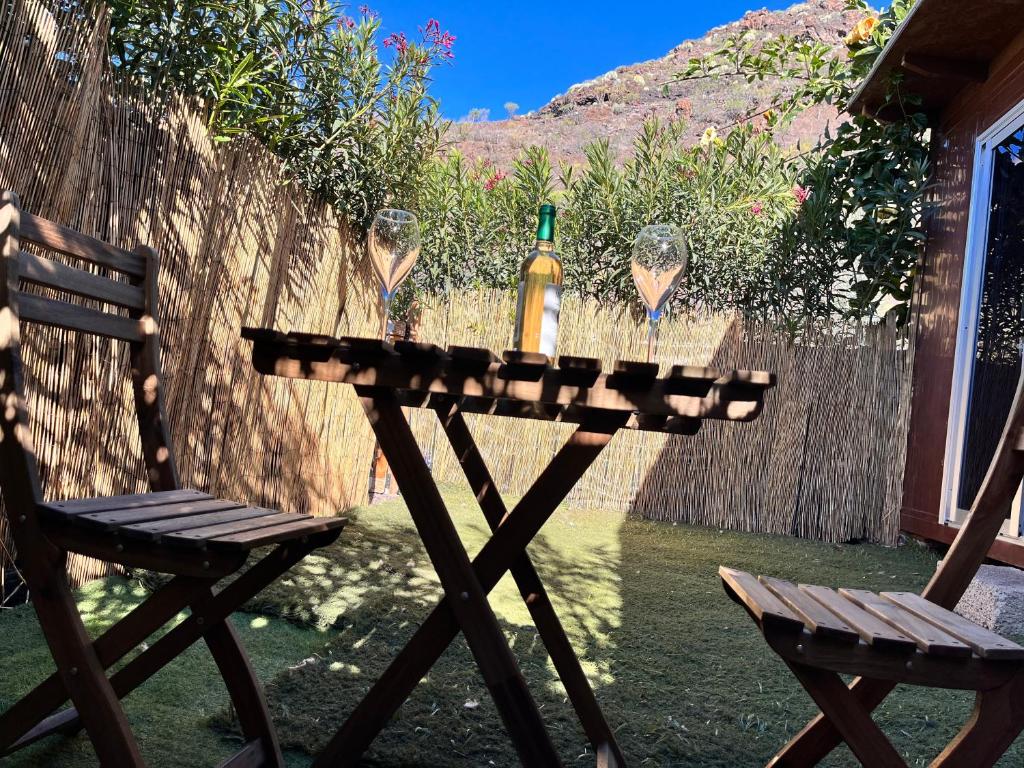 twee stoelen en een tafel met wijnflessen erop bij Residencial giganteide pura naturaleza in Santiago del Teide