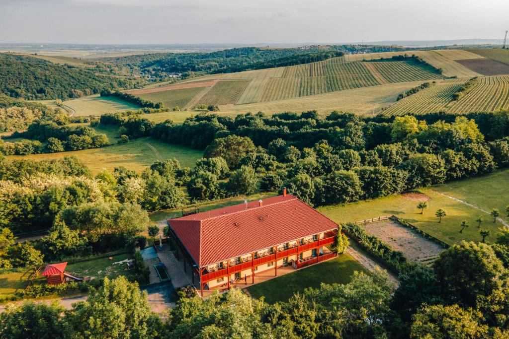 Farma Ovčí Terasy في Němčičky: اطلالة جوية على مبنى كبير بسقف احمر