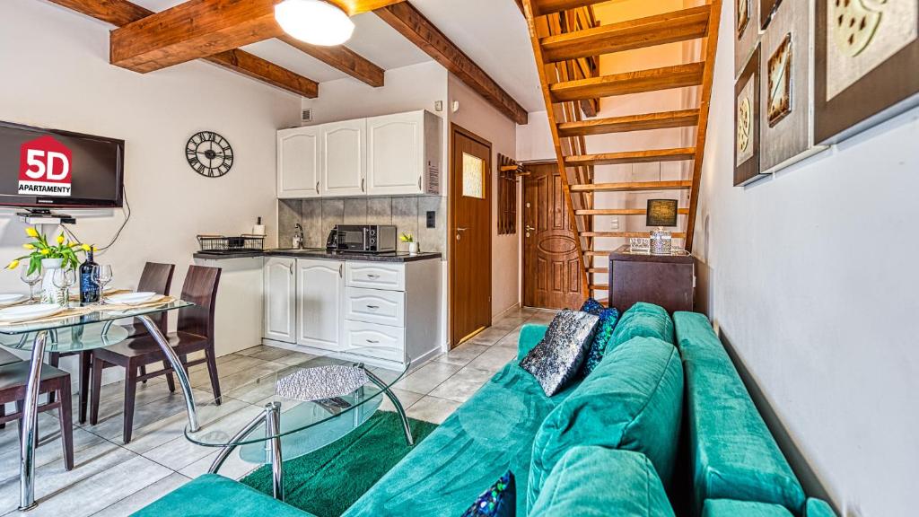 ein Wohnzimmer mit einer grünen Couch und einer Küche in der Unterkunft Karpaczowy Klimat przy Deptaku - 5D Apartamenty in Karpacz