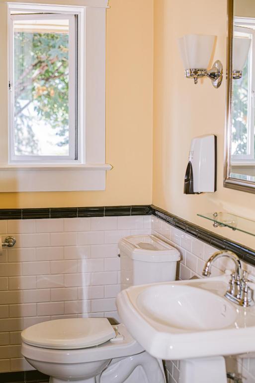 a bathroom with a toilet and a sink and a window at Salt Spring Inn in Ganges