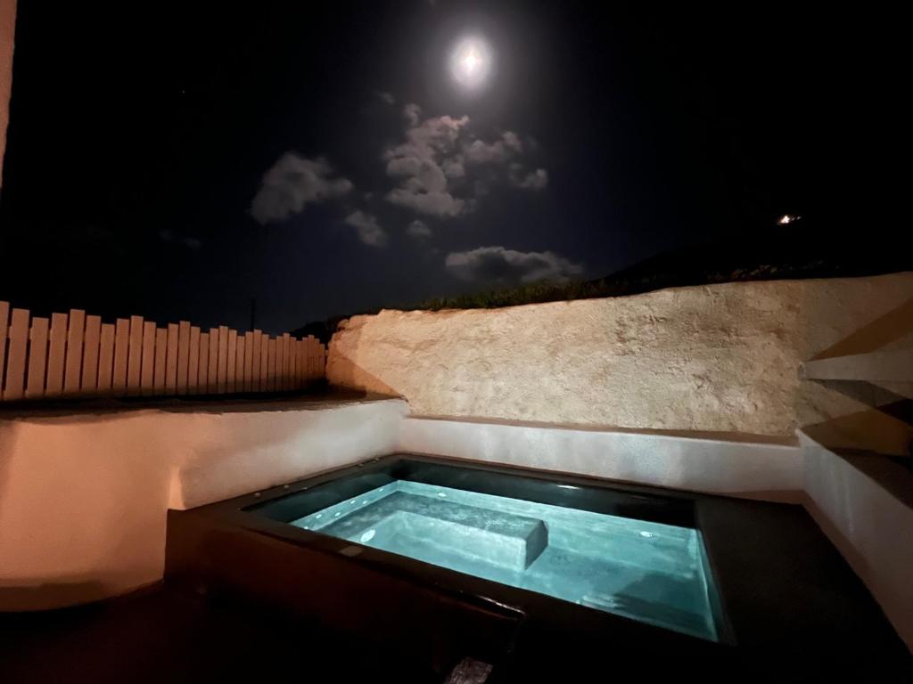 Whirlpool-Badewanne mit Mond im Himmel in der Unterkunft Episkopi Estate Cycladic Villas in Éxo Goniá