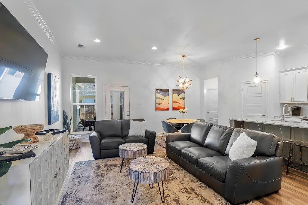 a living room with a couch and chairs and a kitchen at ALL NEW - Designer Luxury 3BR Townhouse - Near LSU in Baton Rouge