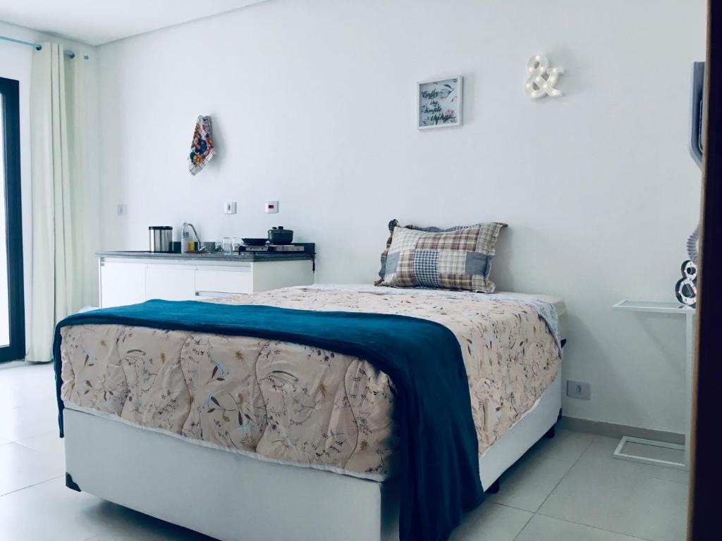 um quarto com uma cama com um cobertor azul em H34 Hotel em Guarulhos