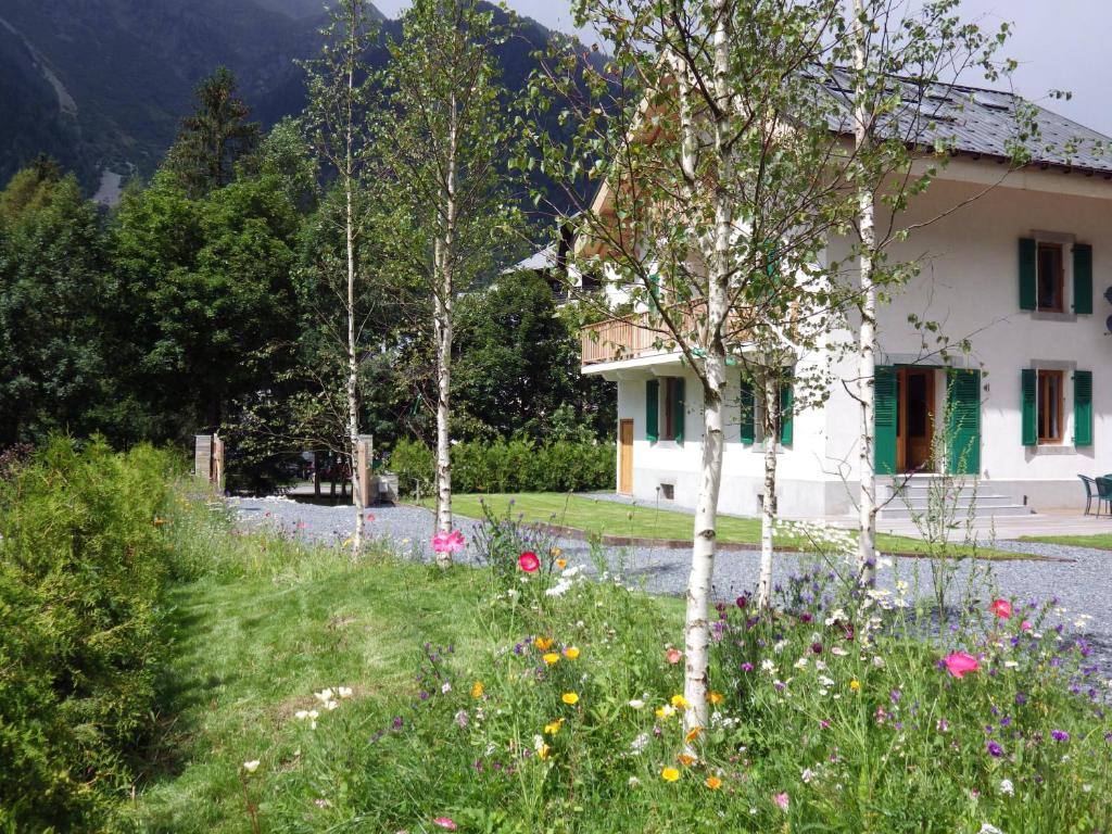 a house and a field of flowers in front of a house at Chalet Oryx in Chamonix-Mont-Blanc