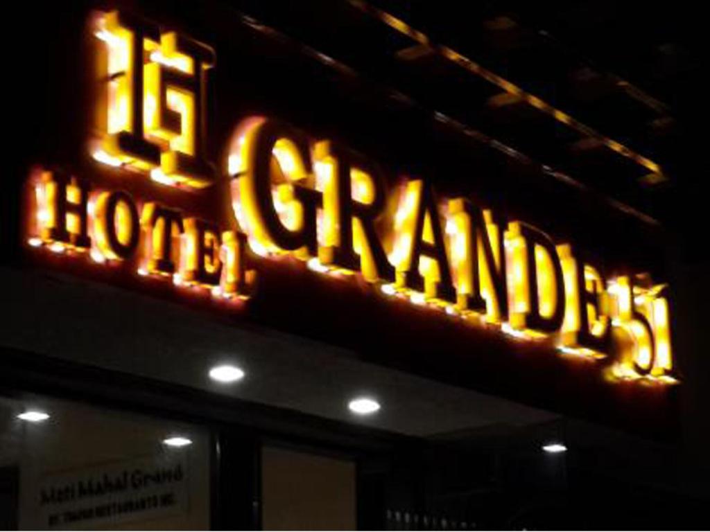 a large neon sign for a hotel sign on a building at Hotel Grande 51 in Navi Mumbai