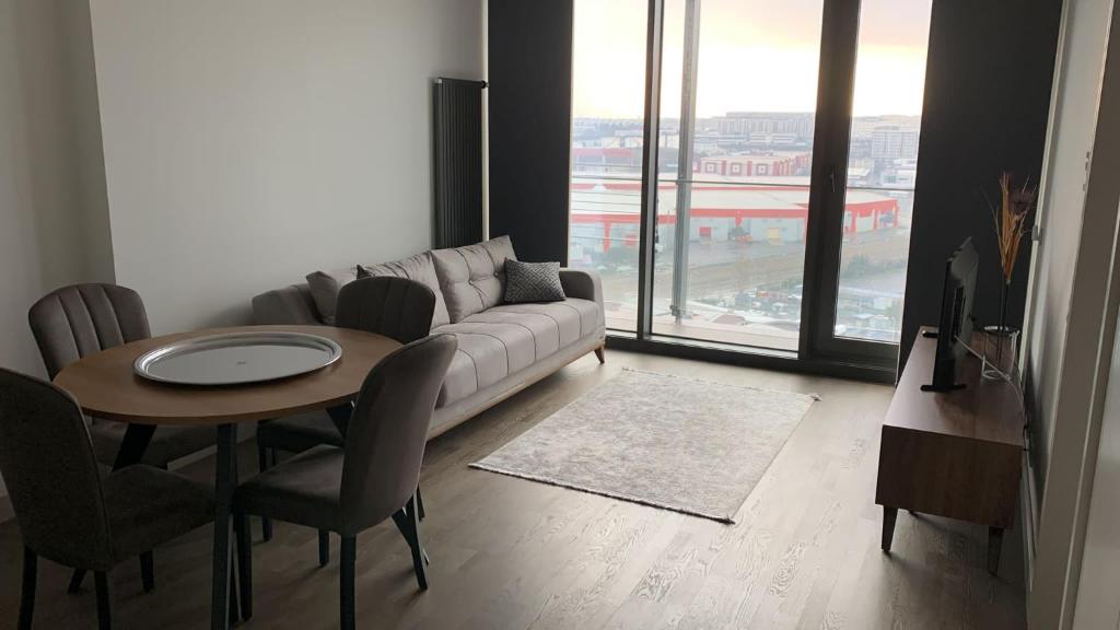 Residence Retro9 B-Blok Ataköy Apart 2 Rooms WIFI Pool Istanbul في إسطنبول: غرفة معيشة مع أريكة وطاولة مع كراسي