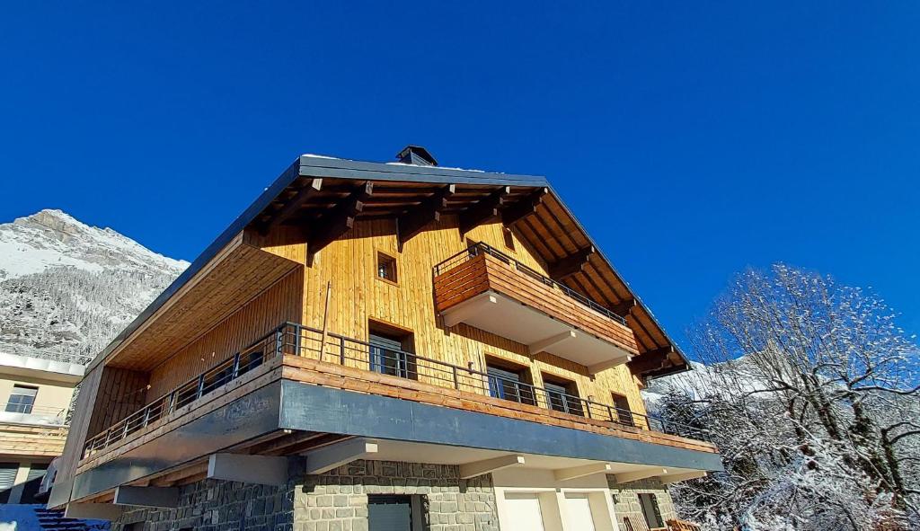 帕西的住宿－New Spacious Appart. Incredible view of Mt Blanc，一座大型木制建筑,在雪中设有阳台