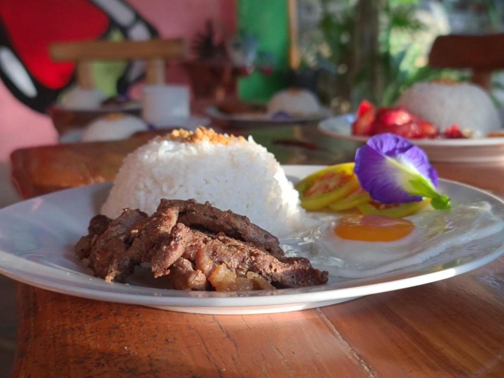 une plaque de nourriture avec du riz et de la viande sur une table dans l'établissement Camp Paraiso Resort, à Salabusob